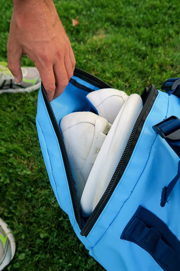 hand holding side pocket on light blue waterproof bag