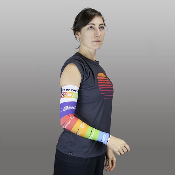 femme portant une manche de compression de couleur arc-en-ciel et un t-shirt gris foncé