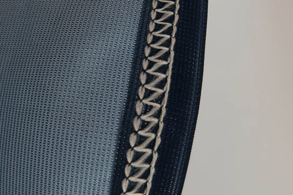 blauwe textiel en witte coverlock-stiksels