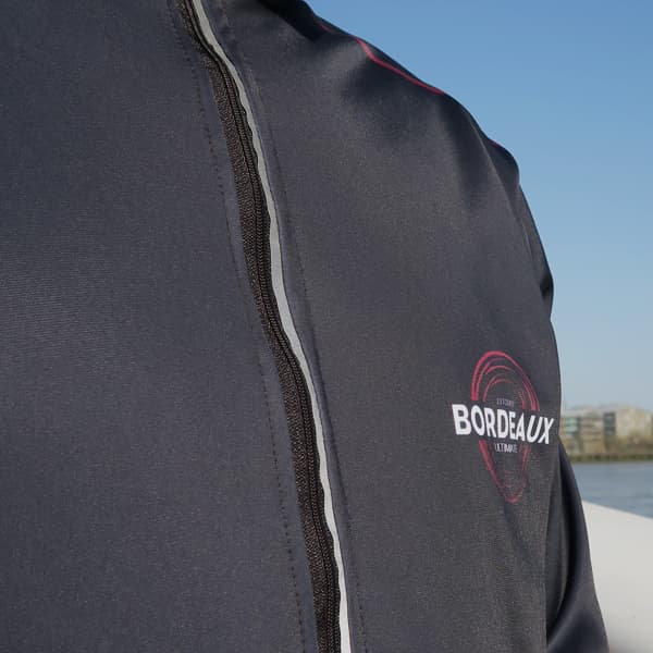 vue serrée d'une veste de sport noire avec une fermeture éclair réfléchissante